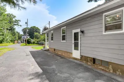 a house with a white door next to a street at Owls Nest Cozy Westfield Home with Fire Pit in Westfield