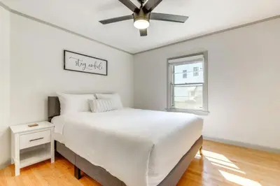 a white bedroom with a bed and a ceiling fan at Owls Nest Cozy Westfield Home with Fire Pit in Westfield