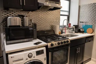 a kitchen with a stove top oven next to a sink at 3 BD next to Central Park in New York