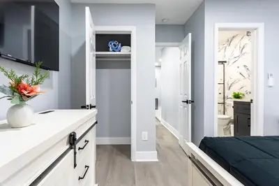 a bedroom with a bed and a tv and a bathroom at Comfort Meets Style 3BR Plus Parking in New Rochelle