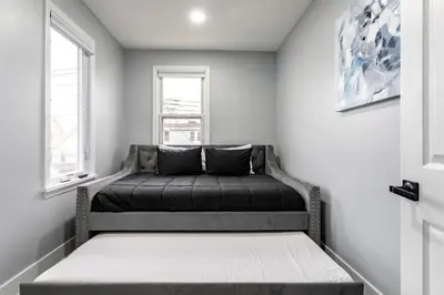 a bed in a room with a window at Comfort Meets Style 3BR Plus Parking in New Rochelle