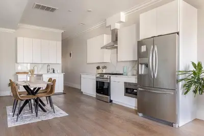 a kitchen with white cabinets and a stainless steel refrigerator at NYC Gateway, 30minutes from Manhattan in Jersey City