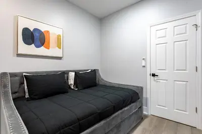 a black couch in a room with a door at Modern Escape 3BR Apt with Parking in New Rochelle