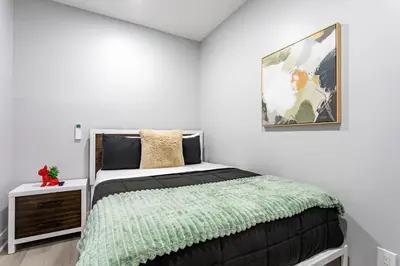 a bedroom with a bed and a picture on the wall at Modern Escape 3BR Apt with Parking in New Rochelle