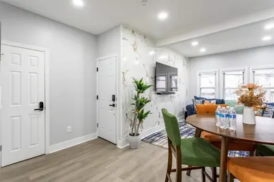 a dining room and living room with a table and chairs at Modern Escape 3BR Apt with Parking in New Rochelle