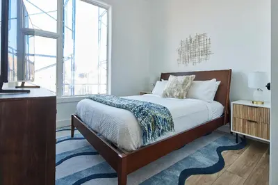 a bedroom with a bed and a large window at Prime Hoboken Lofts in Hoboken