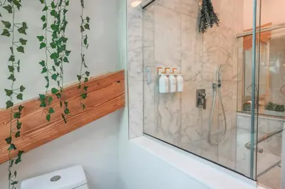 a bathroom with a shower with a glass door at Light filled zen 3BR Penthouse - 7 min to Westport in Weston