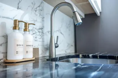 a kitchen counter with two bottles of disinfectants and a sink at Light filled zen 3BR Penthouse - 7 min to Westport in Weston