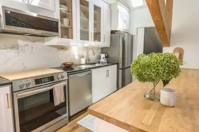 a kitchen with stainless steel appliances and a wooden counter top at Light filled zen 3BR Penthouse - 7 min to Westport in Weston
