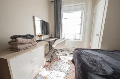 a bedroom with a bed and a desk and a chair at 2 BD Next to Central Park in New York