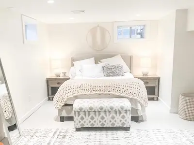 a white bedroom with a large bed and a stool at Modern Westport Studio with Pool Table & Lounge in Westport