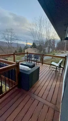 a wooden deck with a couch and chairs on it at Vernon Cozy 2BD Pet-Friendly Mountain Creek in Vernon