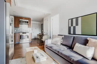 a living room with a couch and a kitchen at Blueground Clinton Hill gym AC nr park NYC-1674 in Brooklyn