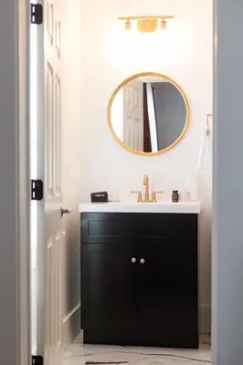 a bathroom with a black vanity and a mirror at Doctor Sax House in Lenox
