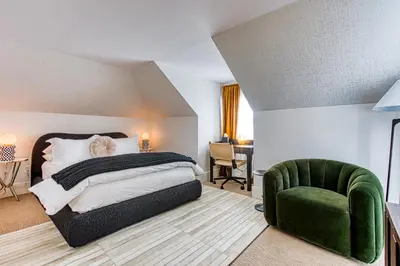 a bedroom with a bed and a green chair at Doctor Sax House in Lenox