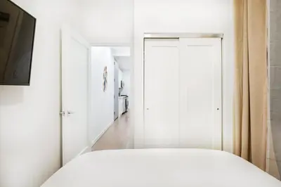 a bedroom with a white bed and a television at 1290-10 New Renovated 2 Bedrooms in UES in New York