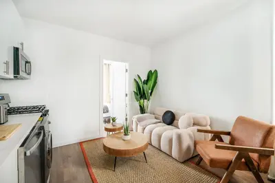 a living room with a couch and a table at 1290-10 New Renovated 2 Bedrooms in UES in New York