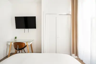 a bedroom with a bed and a desk and a television at 1290-10 New Renovated 2 Bedrooms in UES in New York