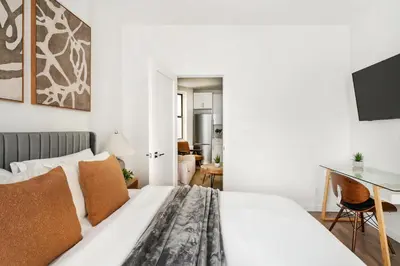 a bedroom with a white bed and a desk at 1290-10 New Renovated 2 Bedrooms in UES in New York