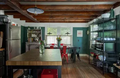 a kitchen with a table and chairs and a refrigerator at Private Creek and Large Yard at the Coziest Cabin in the Catskills in Margaretville