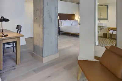 a room with a bed and a table with a couch at Boro Hotel in Queens