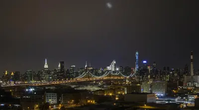 a view of a city at night with a bridge at Boro Hotel in Queens