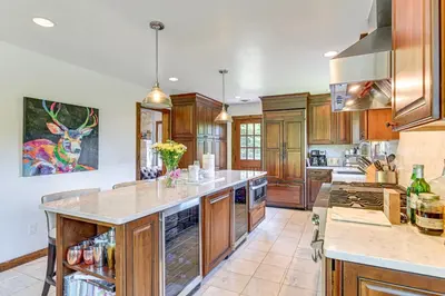 a large kitchen with wooden cabinets and a large island at 3 Mi to Colgate Lake Mtn-View Home, Deck and Grill! in East Jewett