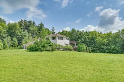 a house in the middle of a green field at 3 Mi to Colgate Lake Mtn-View Home, Deck and Grill! in East Jewett