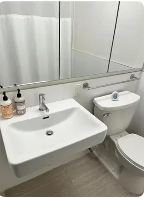 a bathroom with a white sink and a toilet at The Gilbert in New York