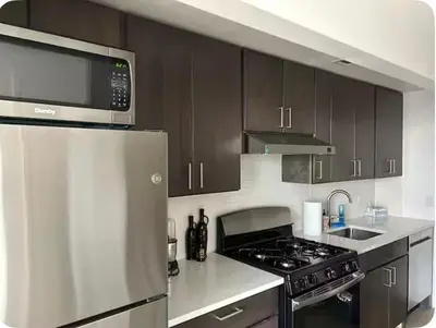a kitchen with a stove and a microwave at The Gilbert in New York