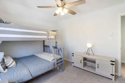 a bedroom with a bunk bed with a ceiling fan and a desk at Family fun at Casa Ledges in Tobyhanna