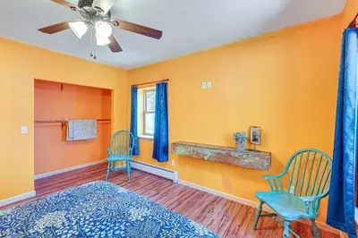 a bedroom with orange walls and blue chairs and a bed at Near Historic Sites Bright Hyde Park Guest Suite in Hyde Park