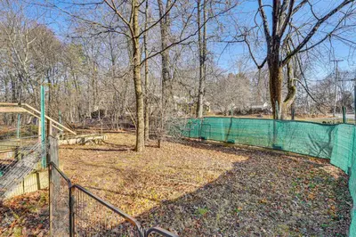a green fence in a field with a tree at Near Historic Sites Bright Hyde Park Guest Suite in Hyde Park