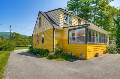 a yellow house with a large window at 1 Mi to Dtwn Beautiful Home in Williamstown! in Williamstown