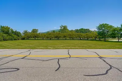 an empty parking lot with cracks in the road at 1 Mi to Dtwn Beautiful Home in Williamstown! in Williamstown