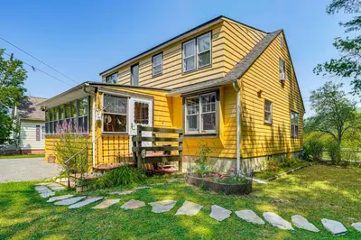 a yellow house with a porch and a yard at 1 Mi to Dtwn Beautiful Home in Williamstown! in Williamstown