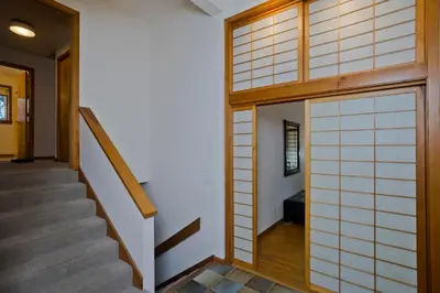 a hallway with a japanese door and stairs at Amherst Woodland Escape in Amherst