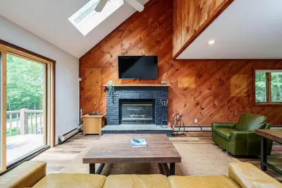 a living room with a fireplace and a tv at Cozy Villager Chalet w Mountain Views and Firepit in Dover