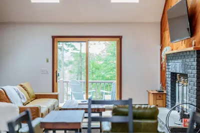 a living room with a couch and a fireplace at Cozy Villager Chalet w Mountain Views and Firepit in Dover