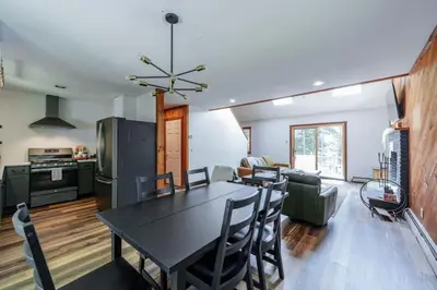 a kitchen and dining room with a black table and chairs at Cozy Villager Chalet w Mountain Views and Firepit in Dover