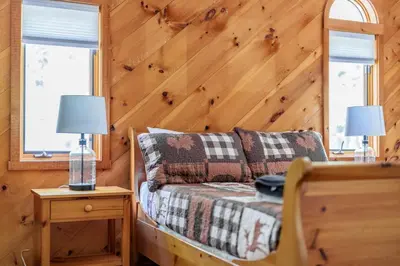 a living room with a couch and two windows at Cozy Villager Chalet w Mountain Views and Firepit in Dover