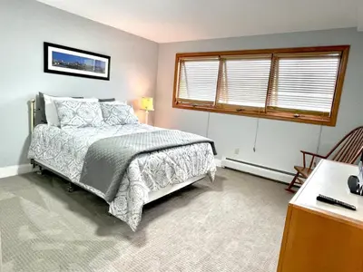 a bedroom with a bed and a desk and windows at Mount Snow Best View - Sauna - HotTub - Pool - Fireplace in West Dover