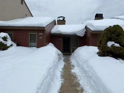 a house covered in snow in front of a house at Mount Snow Best View - Sauna - HotTub - Pool - Fireplace in West Dover