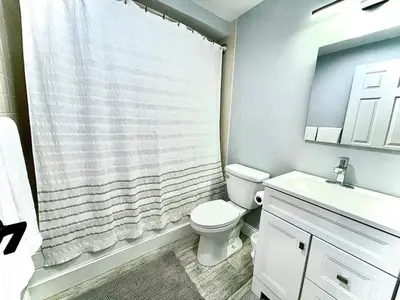 a bathroom with a white toilet and a sink at Mount Snow Best View - Sauna - HotTub - Pool - Fireplace in West Dover