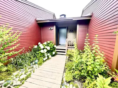 a red house with a pathway leading to the door at Mount Snow Best View - Sauna - HotTub - Pool - Fireplace in West Dover
