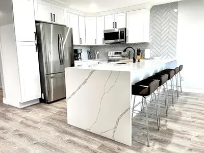 a kitchen with a marble counter top and a refrigerator at Mount Snow Best View - Sauna - HotTub - Pool - Fireplace in West Dover