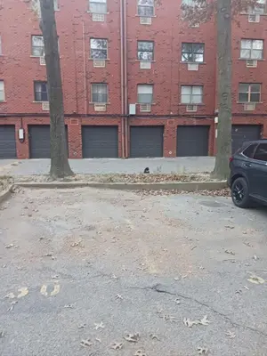 a parking lot in front of a brick building at Comfy Room in Fresh Meadows in Utopia