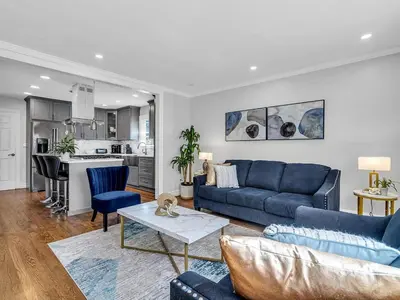 a living room with a blue couch and a table at Suburban 3BR Stylish Oasis in Maplewood