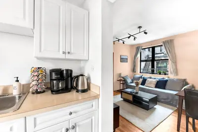 a kitchen and a living room with a couch at Stylish 2 Bedroom Apartment in Chelsea in New York