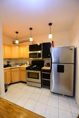 a kitchen with a stainless steel refrigerator and appliances at Great! Private NYC Room in Sunnyside in Haberman